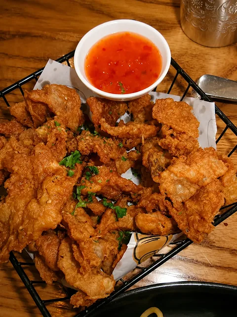 Crispy fried bites with dipping sauce on a café table