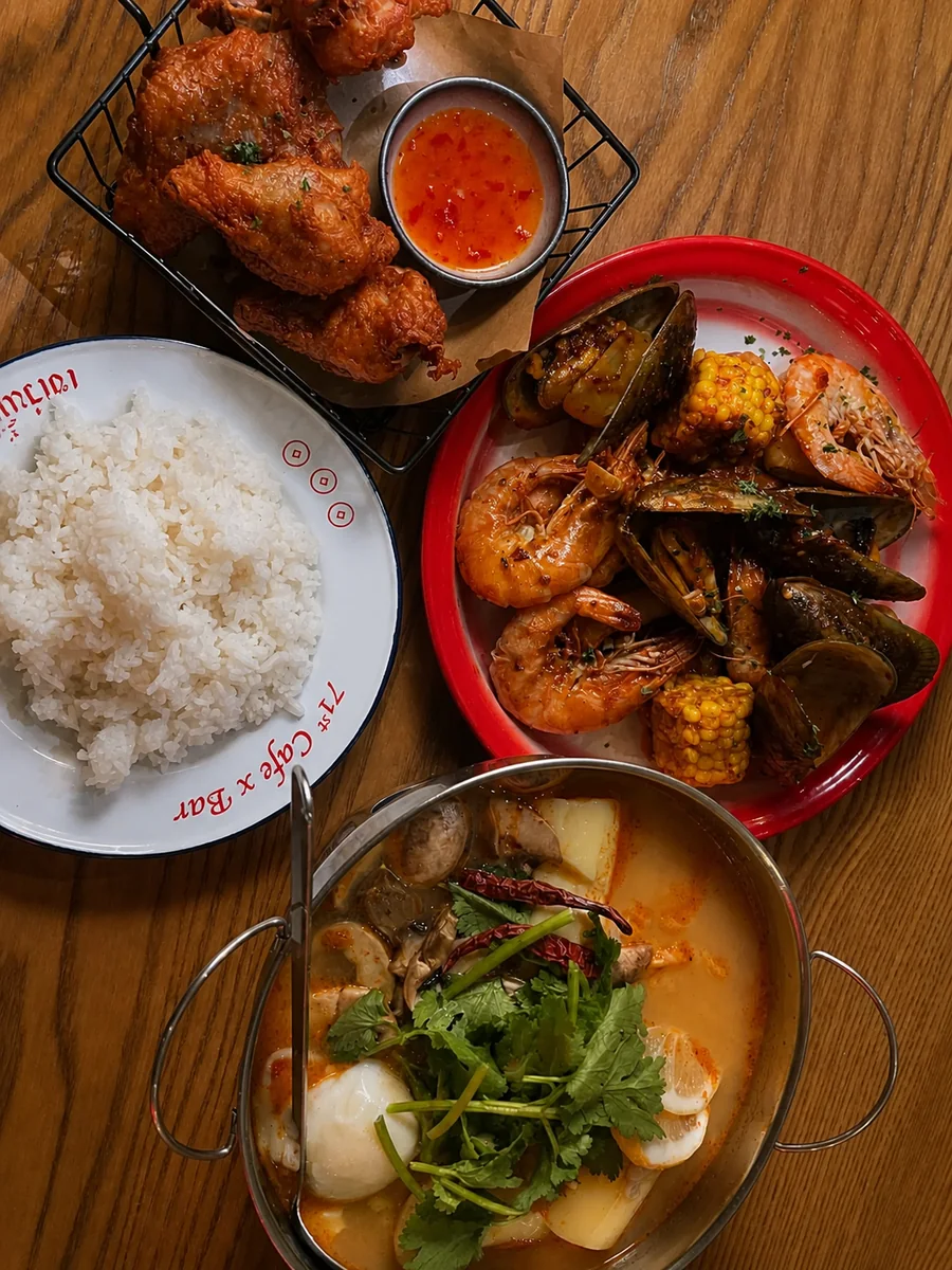 Thai dishes, rice and seafood served across a café table