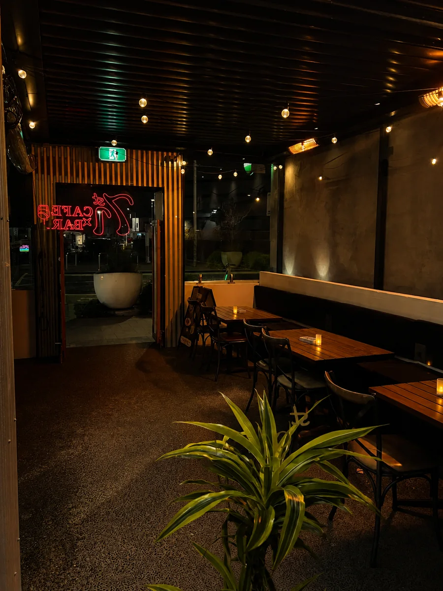 Evening seating and the red 71st Cafe x Bar sign