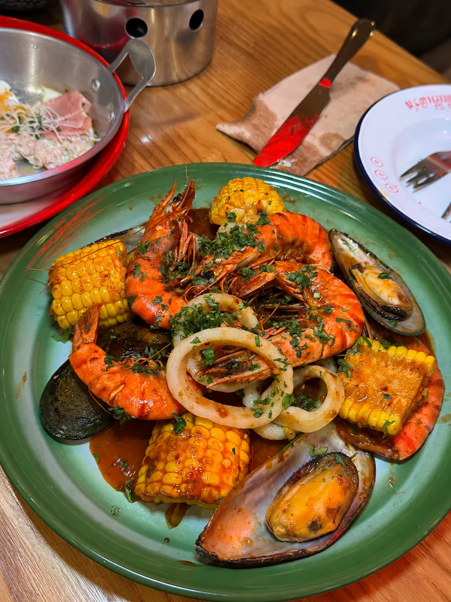 A green platter of prawns, mussels, squid and corn at 71st Cafe x Bar